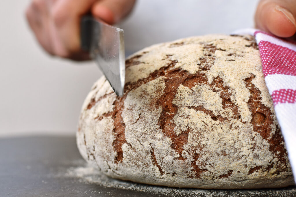 Close-up,Of,A,Body,Of,Bread,Being,Sliced,-,Tasty